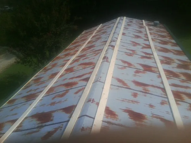 Rusted metal roof panels with new wood purlins before replacement — Storm Damage Roof Repair in Birmingham by Roofing Brothers
