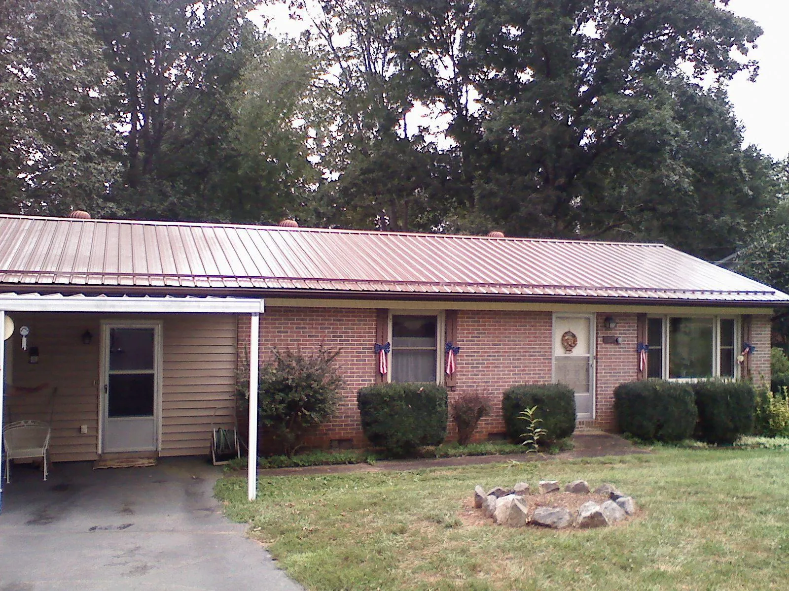 Bronze metal roof and carport on a brick ranch home — Roof Repair work by our crew in Birmingham